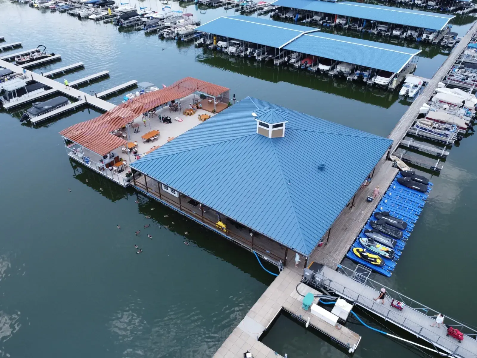 Aerial view of the Clinton Lake marina near Lawrence, KS, with covered boat slips, pontoons and jet skis at the dock
