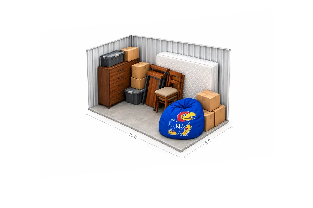 5x10 drive-up storage unit holding a studio apartment's worth of furniture: sofa, dresser, mattress and bed frame, boxes and totes and a KU Jayhawk beanbag chair, at Free State Storage in Lawrence, KS